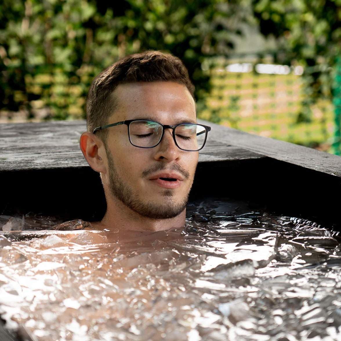 Someone mid-reset in a home ice bath, warm and personal